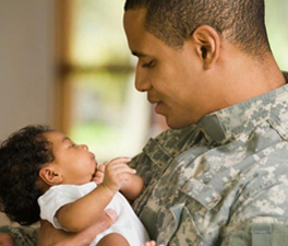 Returning soldier holding newborn baby --- Image by © Ariel Skelley/Blend Images/Corbis